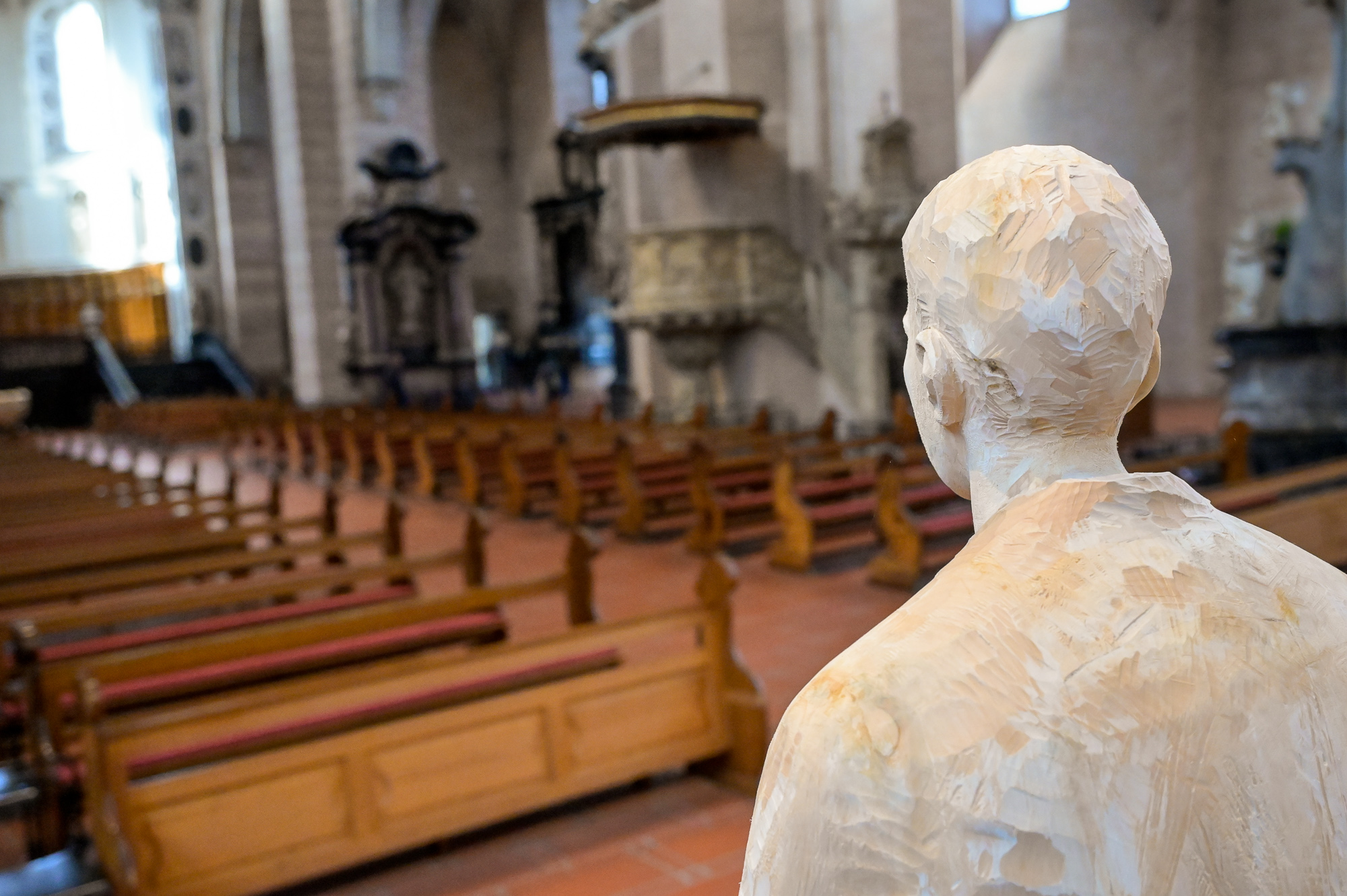 Figur von der Rückseite fotografiert und Blick in den Dom